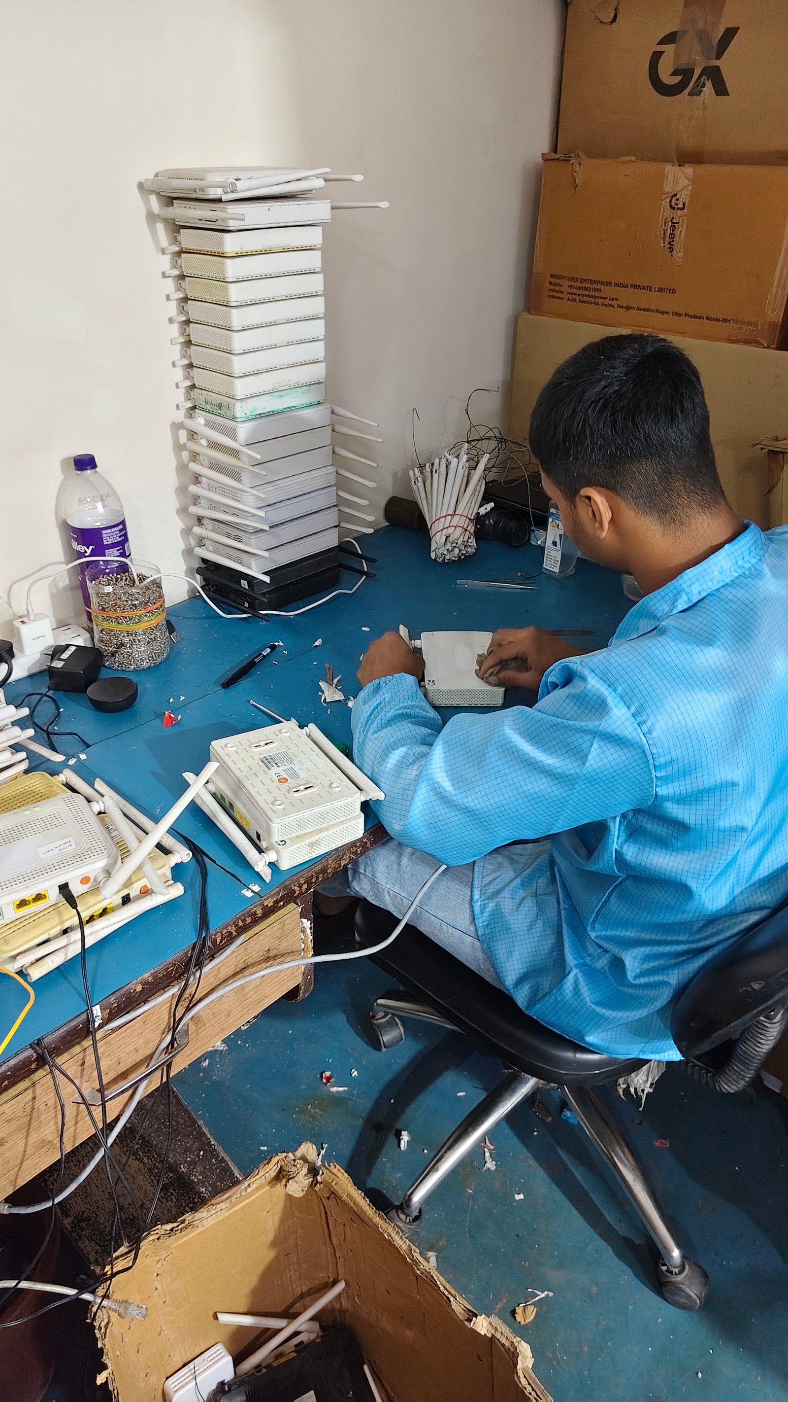 Technician repairing the housing of a broadband device at the workbench