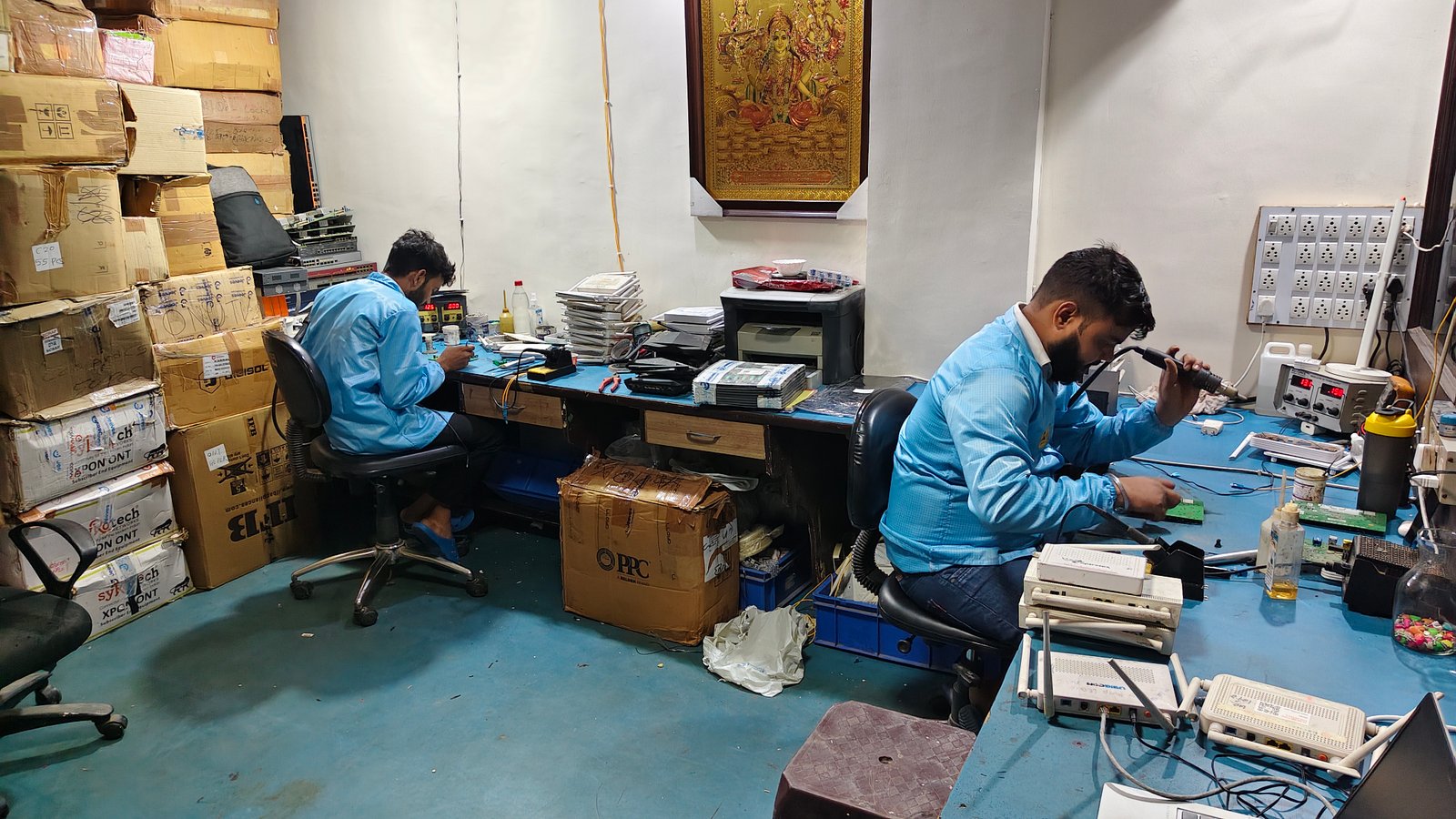 Two technicians performing circuit board rework in the electronics repair lab